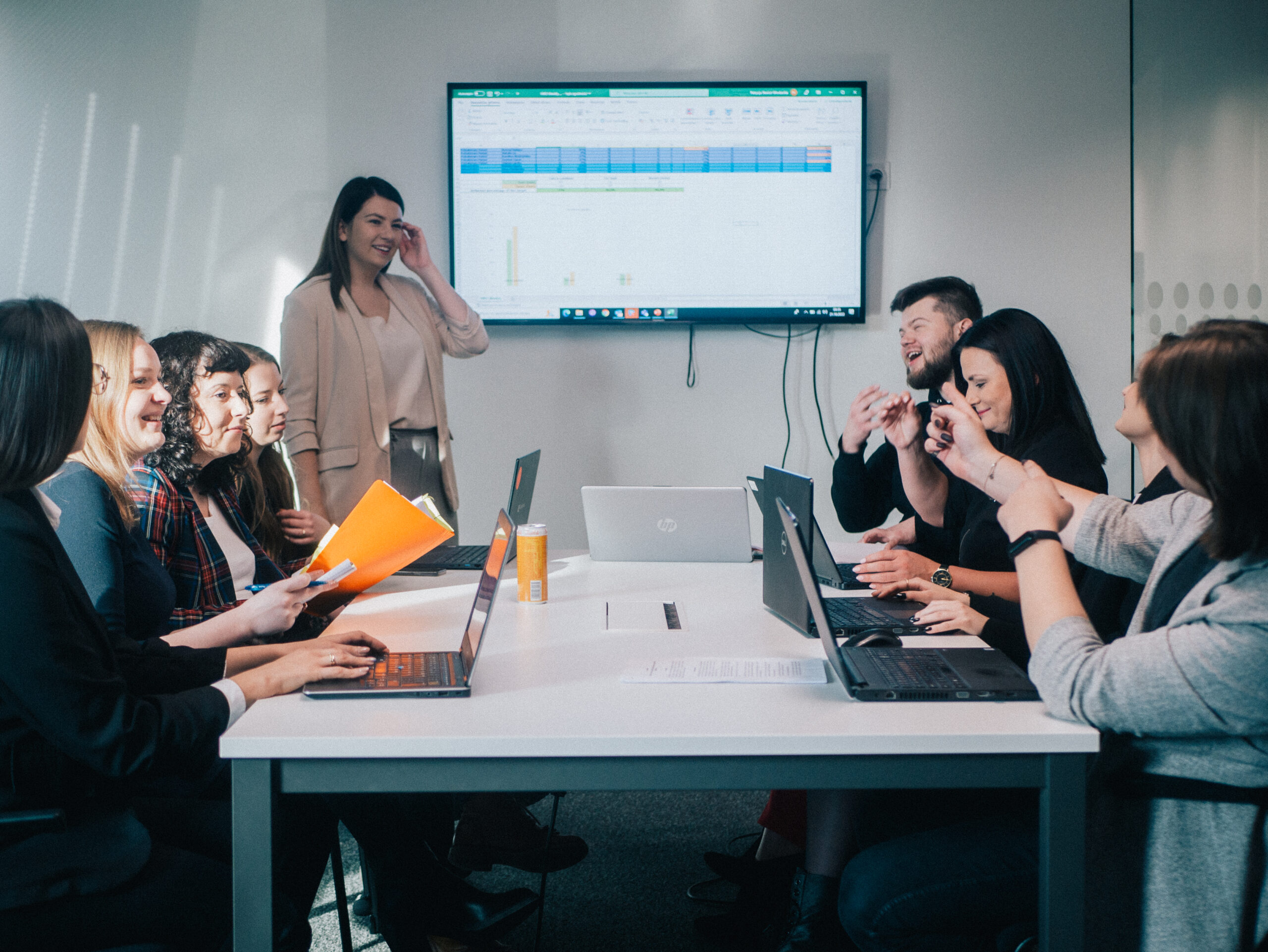 A team meeting around a table with a presentation on screen