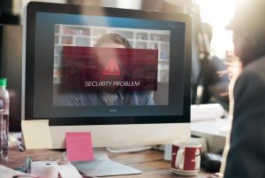 Zdjęcie jest ilustracją do artykułu: Rekrutacja zdalna a ochrona danych osobowych kandydata – na co zwrócić uwagę? Przedstawia rozmowę video dwóch osób. Na ekranie komputera widnieje znak ostrzeżenia i napis " Security Problem"|Rekrutacja zdalna a ochrona danych osobowych kandydata do pracy – na co zwrócić uwagę?|Rekrutacja zdalna a ochrona danych osobowych kandydata do pracy – na co zwrócić uwagę?|