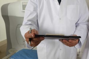 Zdjęcie jest iluistracją do artykułu: Nowa ustawa o zwolnieniach lekarskich. Przedstawia cześciwowo mężczyznę w kitlu