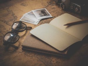 Zdjęcie jest ilustracją do artykułu: Gap year w trakcie kariery zawodowej - dobry pomysł?. Przedstawia rozłożone na biurku zdjęcia