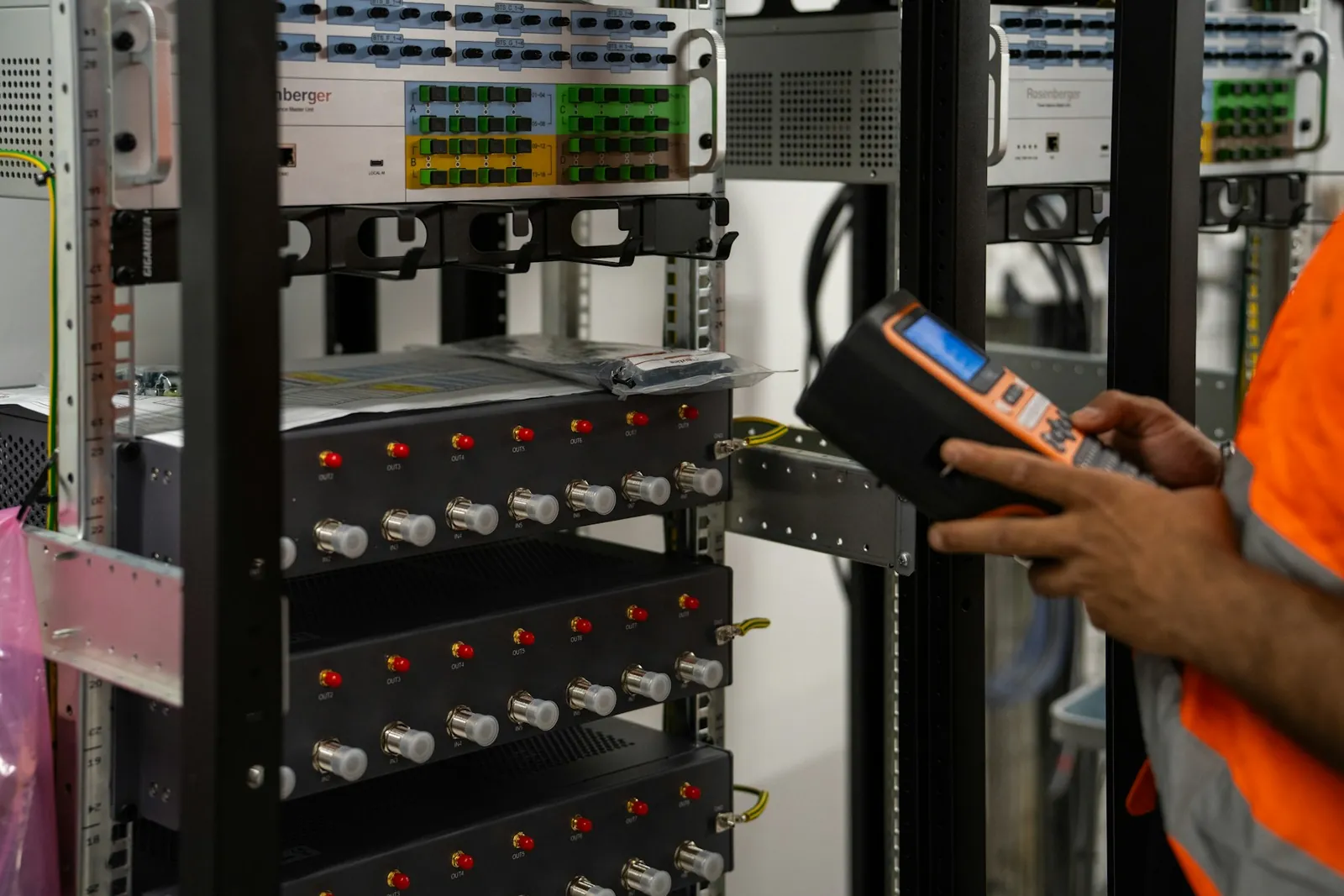 Data centre technician inspecting a server rack with a handheld diagnostic tool in Poland