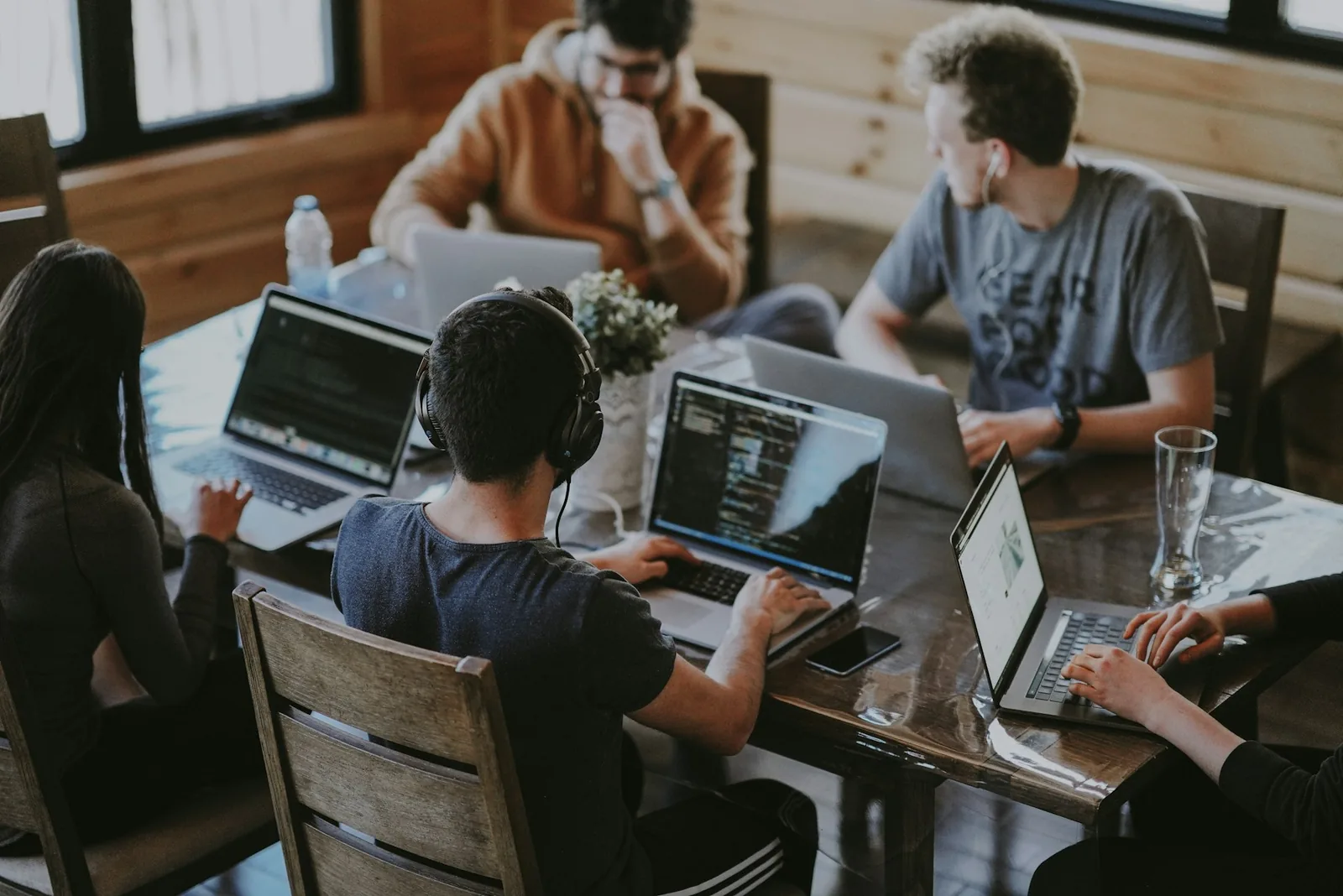 Team members working on laptops around a shared table